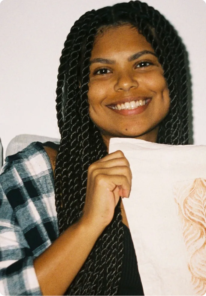 Mariane smiling with her own made pattern made with linolium in a totebag.
