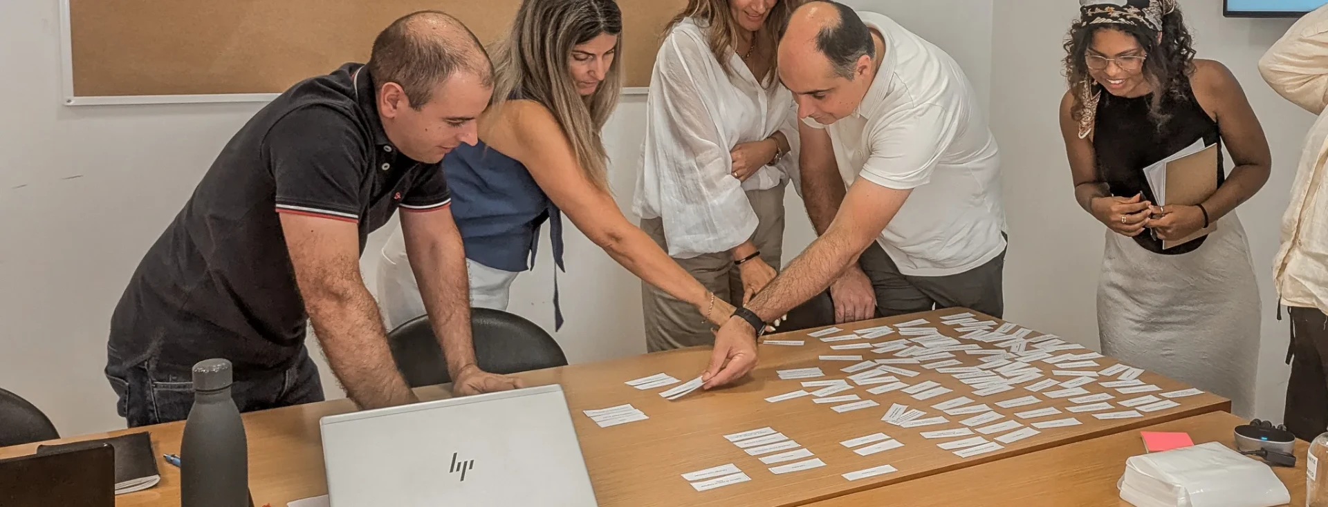 Mariane and a group of people organizing sticky notes during a workshop.